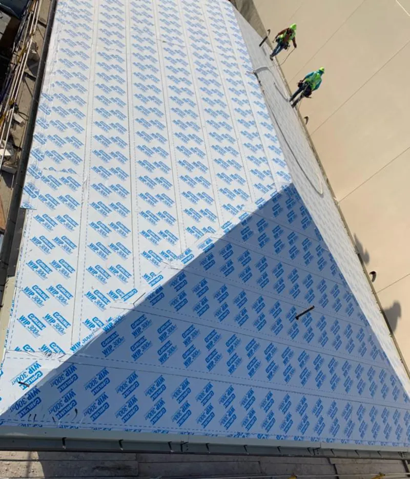 Professional roofers installing underlayment on a metal roof in Beacon Falls